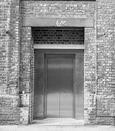 Exterior of an outdoor elevator within a brick building